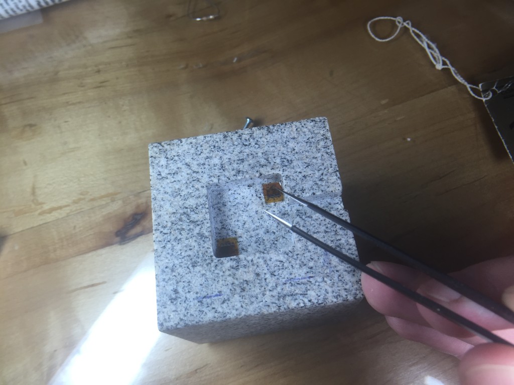 Placing strain gauges under a magnifier with tweezers and epoxy.